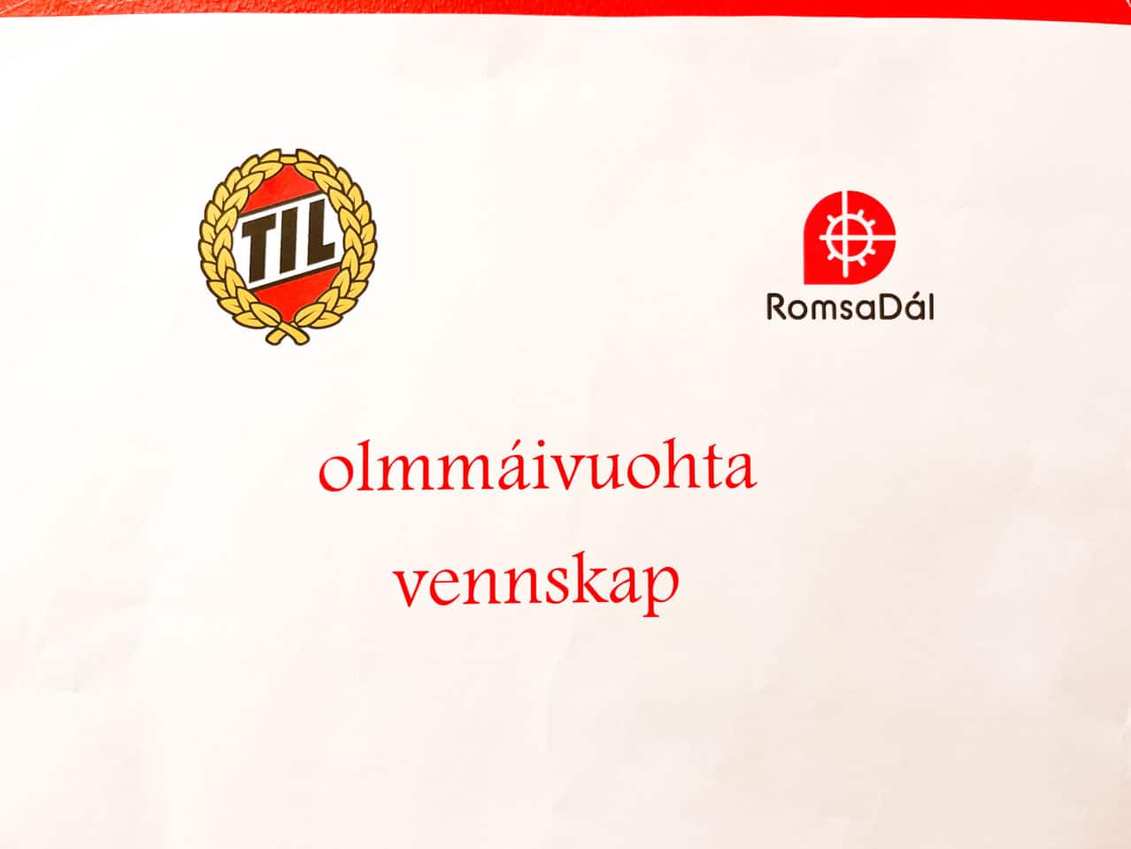TIL logo og RomsaDál logo med tekst: olmmáivuohta/vennskap